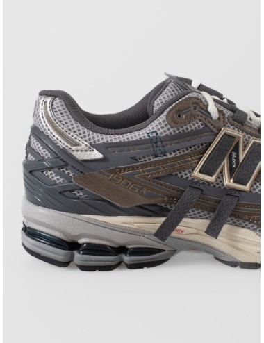 Sneaker New Balance 1906A para hombre en mesh gris con superposiciones marrón thunder brown y azul grisáceo.