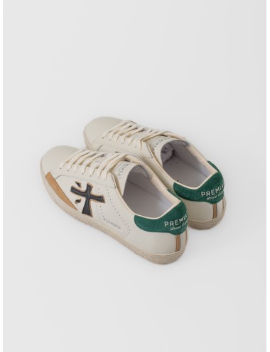 Zapatilla blanco roto Premiata Steven 7284 con logo negro, talón verde y suela gráfica