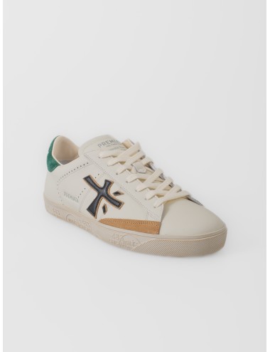 Zapatilla blanco roto Premiata Steven 7284 con logo negro, talón verde y suela gráfica