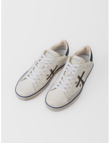 Zapatilla blanca Premiata Steven 7503 con logo lateral oscuro, talón azul y suela gráfica